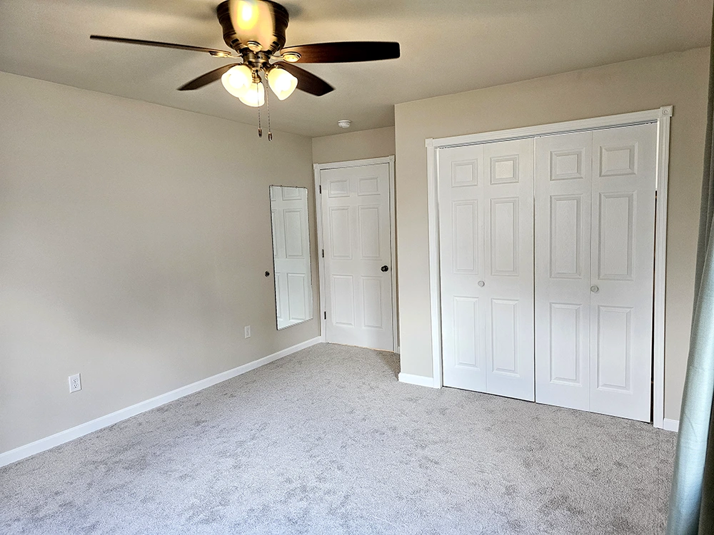 A well-lit, generously sized closet and a large dressing mirror enhance this master bedroom.